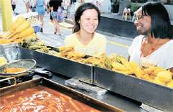 韓国語を勉強中の中国人（左）と英語講師として働く米国人が２８日午後、ソウル弘益大学の前でトッポッキと練り物を食べている。