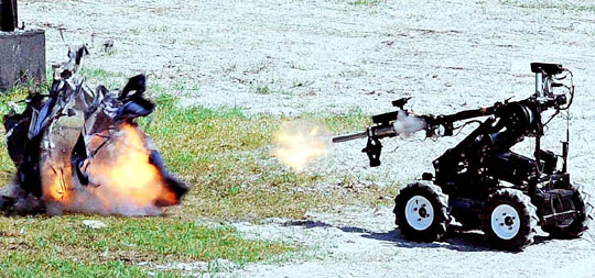 爆弾除去ロボットが爆発物除去のデモンストレーションを見せている。