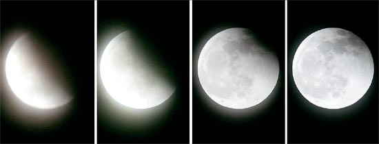 ２１日午後、皆既月食が終わった後、月が地球の影から徐々に抜け出している。