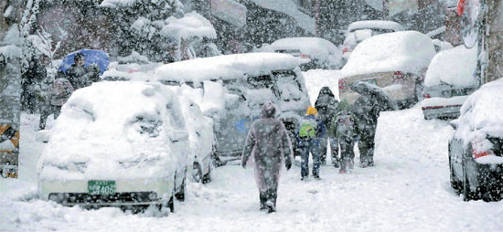 釜山（プサン）地域に大雪注意報が出された１４日、下校する生徒が雪の中を歩いている。