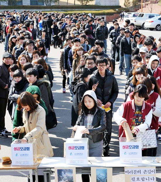 天安南ソウル大学の教職員と学生が２２日、募金箱に寄付金を入れている（写真＝天安南ソウル大学）。