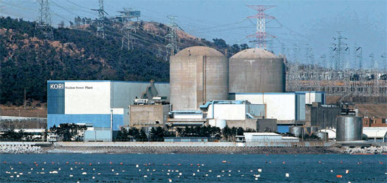 古里原子力発電所。原子炉の建物の前は防波堤がなく海が広がり、後ろには山が控えている。