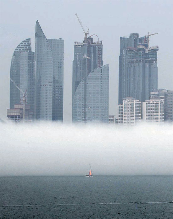 ８日、釜山市海雲台の水営湾ヨット競技場付近の高層マンションの下部が海霧に包まれている。