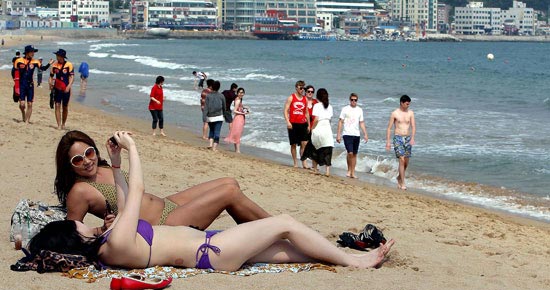 １日、釜山（プサン）海雲台（ヘウンデ）海水浴場で避暑客が水着姿で日光浴を楽しんでいる。