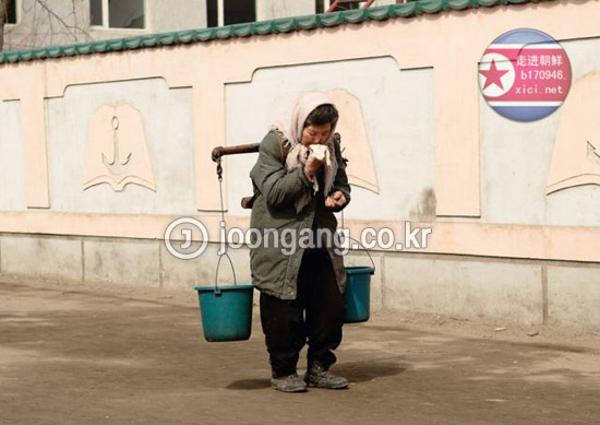 北朝鮮平壌市の最新式超高層アパートの住民は、毎日バケツを持って出勤する。