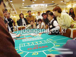 エンペラー娯楽ホテル内のカジノで北朝鮮女性ディーラーがカードを配っている。