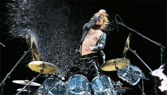 Ｘ ＪＡＰＡＮのＹＯＳＨＩＫＩが１４日、千葉で開かれたサマーソニック公演でドラムスティックを投げ情熱的な演奏をしている。２００７年に１０年ぶりに再結成されたＸ ＪＡＰＡＮを見るため日本各地から５万人余りが集まった（写真＝ＫＲホールディングス提供）。