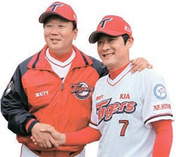 握手をする宣銅烈（ソン・ドンヨル）監督（左）と李鍾範（イ・ジョンボム、右）