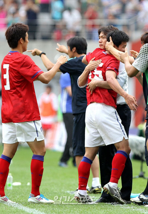 選手と抱擁しているオリンピック（五輪）サッカー代表チームの洪明甫（ホン・ミョンボ）監督（写真右側）。