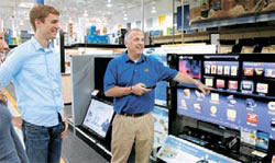 米国の電子製品販売店ベストバイで販売員がサムスンのスマートテレビシリーズを紹介している。