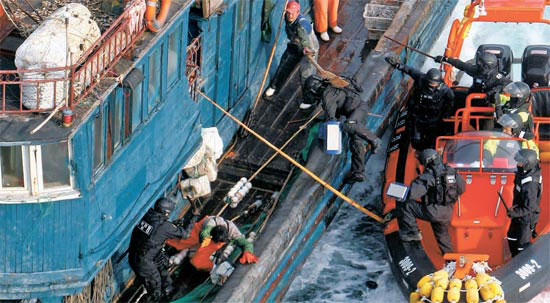 韓国の海洋警察特攻隊員が１６日、違法操業をしていた中国漁船に飛び乗ると中国船員が竹の棒を振り回し抵抗している。