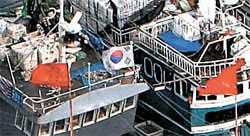 韓国の海洋警察の取り締まりを避けるために太極旗を立てている中国漁船。