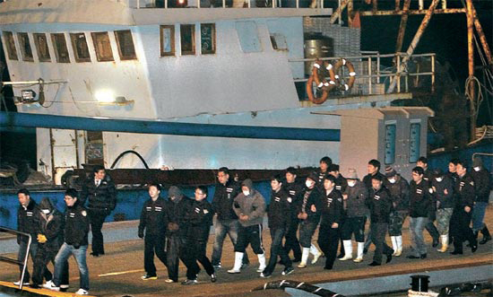 韓国海洋警察に拿捕された中国魯文漁１５００１号の船員が１３日、仁川港海洋警察埠頭に到着し、仁川海洋警察署に連行されている。