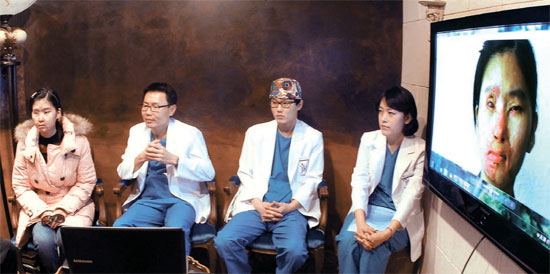 １４日、ソウル江南区（カンナムグ）ＪＫ成形外科で、塩酸事故で顔に火傷を負ったマレーシア人女性タン・フィリンさん（左端）がチュ・グォン院長（左から２人目）ら医療陣と再建成形手術について相談している。 