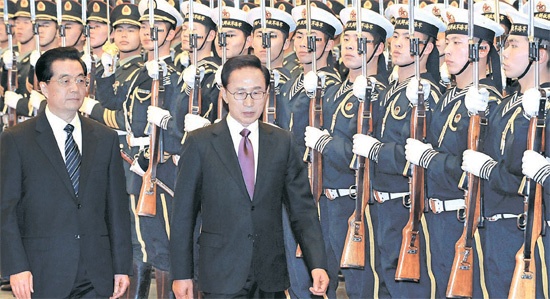 中国を国賓訪問中の韓国の李明博（イ・ミョンバク）大統領が９日、北京人民大会堂で開かれた公式歓迎式で、中国の胡錦濤国家主席と閲兵している。