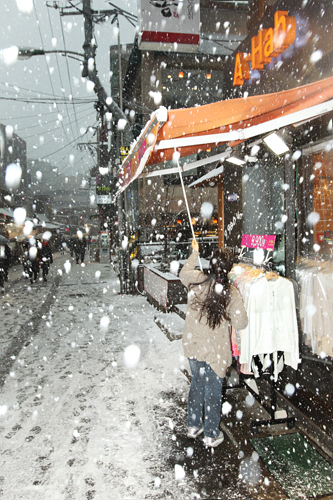 雪の重さでつぶれないように、店のテントに積もった雪をはらっている人の姿も見られます。