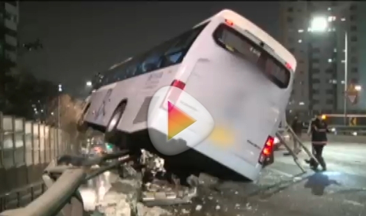  ２０日午後８時ごろ、ソウル西大門区（ソデムング）の金華（クムファ）トンネルの前の高架道路で衝突事故を起こした観光バスが間一髪でガードレールに引っかかっている。（写真＝ＪＴＢＣニュース放送キャプチャー）。