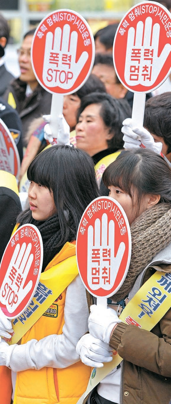 校内暴力根絶に向けた「ストップ校内暴力」市民運動宣布式が２２日に大邱（テグ）市立中央図書館の視聴覚室で開かれ、参加者が大邱デパートの前広場まで行進し、「ストップ」を叫んでいる。