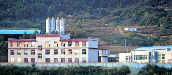 中国吉林省図們にある脱北者収容所「図們辺境管理所」。塀は鉄条網で囲まれ、２つの建物の間に監視塔が見える。脱北者のリュ・ソンジャさんが２００２年に収容されたのは左側の建物。右側の建物は収容施設が狭くその後に新築された。図們収容所は北へ送還される脱北者を受け入れる所として知られる。