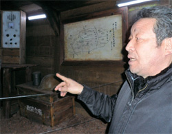 地下壕の通信室で当時の状況を説明する済州平和博物館のイ・ヨングン館長。