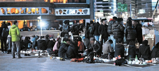 １１日午前、ソウル広場に設置されたテント周辺に置かれたビールボークス。１日午後、ソウル広場で大学生デモ隊が酒を飲んでいる。 デモ隊は昨年１２月からソウル汝矣島（ヨイド）韓国取引所前で行ってきた占拠デモを、この日、ソウル広場に移した。