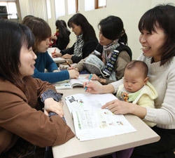 ５日に釜山市海雲台区の住民自治センターを訪れた日本人たち（右側）がボランティアメンバーらからマンツーマンで韓国語を学んでいる。