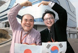 先月２８日、日本ソフトバンクのハガワラ・ミノル氏（左）と韓国のＫＴ－ＳＢデータサービスのイ・ヨンギ・チーム長が金海（キムヘ）データバンク社屋の前で協力を強調するポーズを見せている。