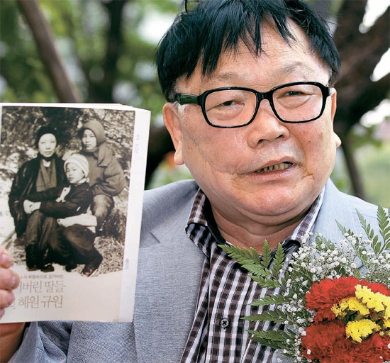 申淑子さんの夫の呉吉男さんが８日、ソウル・プレスセンター外信記者クラブで記者らの質問に答えている。彼は自身の著書「なくした娘たち、オー！ヘウォン・ギュウォン」も見せた。胸に付けているカーネーションは両親の日に合わせセヌリ党のハ・テギョン当選者が付けたもの。