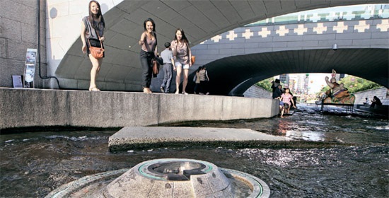 ソウル清渓川（チョンゲチョン）の八石潭（パルソクダム）に市民がコインを投げ入れている。