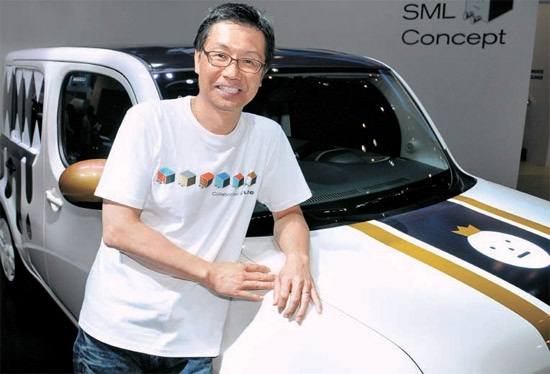 内藤賢司韓国日産社長が「スティッキーモンスターラボ」とのコラボで完成させた「キューブ」のそばで立っている（写真＝韓国日産自動車）。
