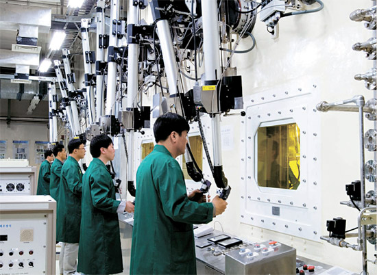 韓国原子力研究院の研究員がロボットアームで使用済み核燃料を操作しながら、パイロプロセシング技術開発を行っている。