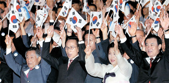 李明博（イ・ミョンバク）大統領が１５日、ソウル世宗文化会館で開かれた光復節（解放記念日）慶祝式で万歳三唱をしている。左側から朴維徹（パク・ユチョル）光復会長、李明博大統領、金潤玉（キム・ユンオク）大統領夫人、姜昌熙（カン・チャンヒ）国会議長。