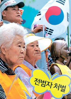 ２９日、ソウル中学洞（チュンハクトン）日本大使館の前で、「日本軍慰安婦問題解決のための定期水曜デモ」が開かれた。慰安婦被害者のイ・オクソンさん、パク・オクソンさん（左から）が「戦犯処罰」と書かれたプラカードを持っている。