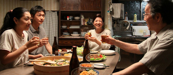 映画「かぞくのくに」で、２５年ぶりに北朝鮮から日本に来た兄（左から２人目、井浦新）が妹（左、安藤サクラ）と夕食を一緒に食べている。脳腫瘍という診断を受けた兄に直ちに帰国指示が出る（写真Ｓｔａｒ　Ｓａｎｄｓ）。