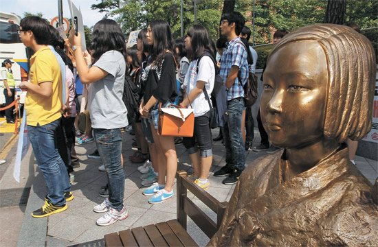 ９日、慰安婦少女像の横で学生たちが日本の独島領有権主張撤回と慰安婦に対する謝罪を求めている。