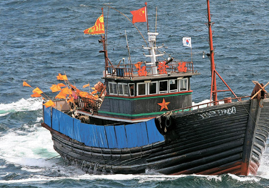 先月違法操業した中国“鉄甲船”＝先月２４日、済州市遮帰島の西側１４０キロメートル海上、韓国側ＥＥＺより２９キロメートル内側で、高さ約１．５メートルの鉄板を装備し、１．６メートルの串２０本余りを設置した中国漁船が済州海洋警察の検問に応じず逃走している。この日済州海域に現れた中国漁船１０隻余りはすべて海洋警察の取り締まりを妨害するために鉄串と鉄板を設置していた。韓国領海で操業する多くの蚒国漁船は１６日に公開されたこの写真の漁船のように太極旗を付けている（写真＝済州海洋警察）。