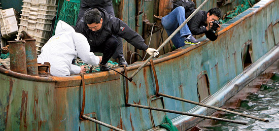 木浦海洋警察捜査官が１７日、全羅南道木浦海洋警察の専用埠頭で、韓国海洋警察の取り締まり船の接近を防ぐために設置された中国漁船の鉄の棒を調べている。