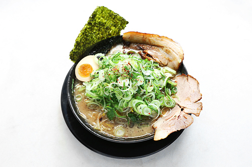 器からはみ出すほど大きなチャーシューが目を引くラーメンは、ねぎ、もやしなどのトッピングを無料で増量することができてお得と評判に。食事時にはお店の外に行列ができるのほどの人気です。