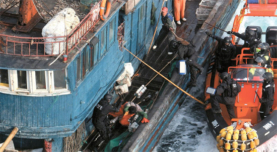 竹の棒を振り回す中国船員＝昨年１１月、於青島沖海上で海洋警察による違法操業の取り締まりに中国船員が竹の棒を振り回し抵抗している。
