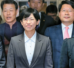 統合進歩党の李正姫候補が１６日に候補辞退記者会見を終え微笑を浮かべ会見場を出ようとしている、後列左からカン・ビョンギ非常対策委員長、キム・ソンドン議員、オ・ビョンユン議員。