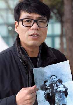 ファン・インチョルさんが、北朝鮮に拉致された父ファン・ウォンさん、親戚と一緒に撮った写真を持っている。 ファンさんが拉致された１９６９年の春に撮った写真だ。 
