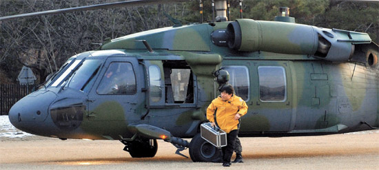 １３日、韓国原子力安全技術院の研究員が陸軍のヘリコプターで移送した放射性物質が入ったかばんを研究棟に移している。