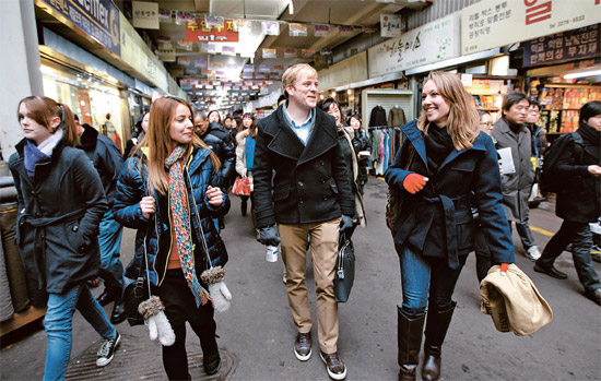 ドイツから来たサブリナ・マイヤーさん（右）がソウル市グローバルインターンシッププログラムに参加した外国人の友人と６日、ソウル鍾路区の広蔵市場を歩いている。