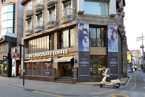 街でよく見かけるコーヒーチェーン店。韓国ドラマでも日常的な風景として頻繁に登場するようになりました。「DE CHOCOLATE COFFEE」はチョ・インソン＆ソン・ヘギョ主演「その冬、風が吹く」のロケ地。手作りチョコレートが人気で放送開始後売り上げが急上昇しているそう。