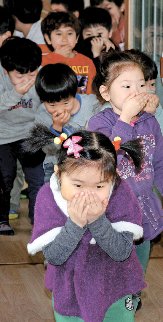 １５日午前、ソウル陽川区（ヤンチョング）のソウル陽木（ヤンモク）小学校で子供消防安全教育に参加した幼稚園生が手で顔をおおったまま煙退避体験をしている。（写真＝陽川消防署）