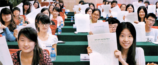 １５日に北京で第７回成均館ハングル白日場が開かれた。中国人大学生参加者が「愛憎」をテーマに作成した答案用紙を挙げて見せている。