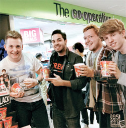 英国ロンドンのスーパーマーケットチェーン店『ザ・コーポレーション』で最近開かれたサンプリング行事で、現地の人たちが農心英国法人が無料で配った辛ラーメンカップラーメンを持って笑顔を見せている。（写真＝農心）
