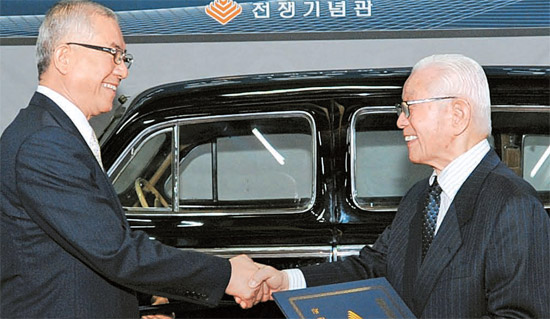 池甲鍾（チ・ガプジョン）国連韓国参戦国協会会長（右）が１６日、ソウル竜山区の戦争記念館で、宣映済（ソン・ヨンジェ）館長に金日成（キム・イルソン）主席が乗っていたリムジンを寄贈した後、握手している。（写真＝戦争記念館）