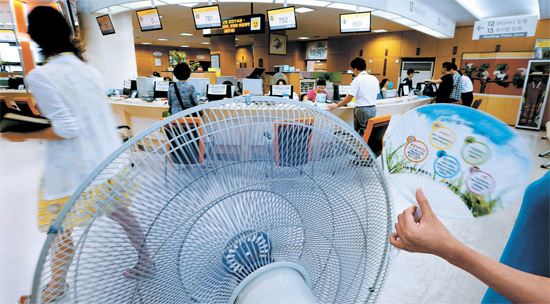 政府・公共機関が冷房を止めた１２日午後、ソウル・鍾路区庁の総合請願室ではエアコンの代わりに大型扇風機が稼動している。
