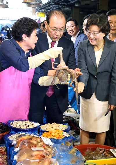 韓国与党セヌリ党の黄祐呂（ファン・ウヨ）代表が１１日、ソウル鷺梁津（ノリャンジン）水産市場を訪れた。タコを手に取りながら商人の話を聞いている。